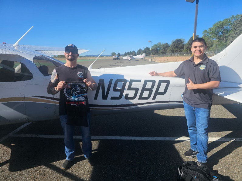 Winston Cooper and instructor Luke Smith beside an airplane after Winston’s first solo flight.