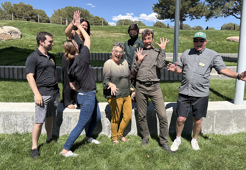 The seven staff members of the tels department acting silly in a group outdoors: An Pfister, Max O'neil, Barrett Johnson, Nick DiPaolo, Christina Goldsmith, Cheryl Colan and Thatcher Bohrman