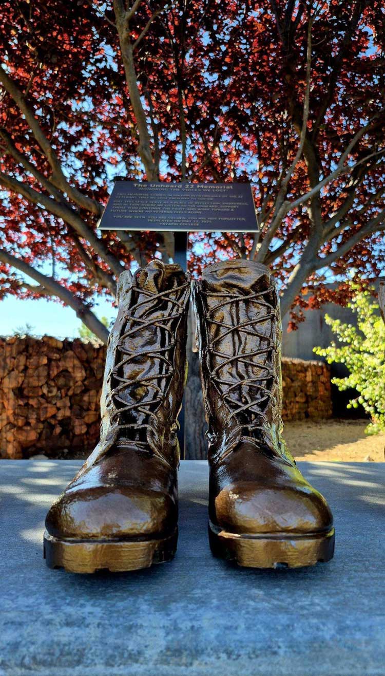 A pair of memorial boots beneath the commemorative plaque.