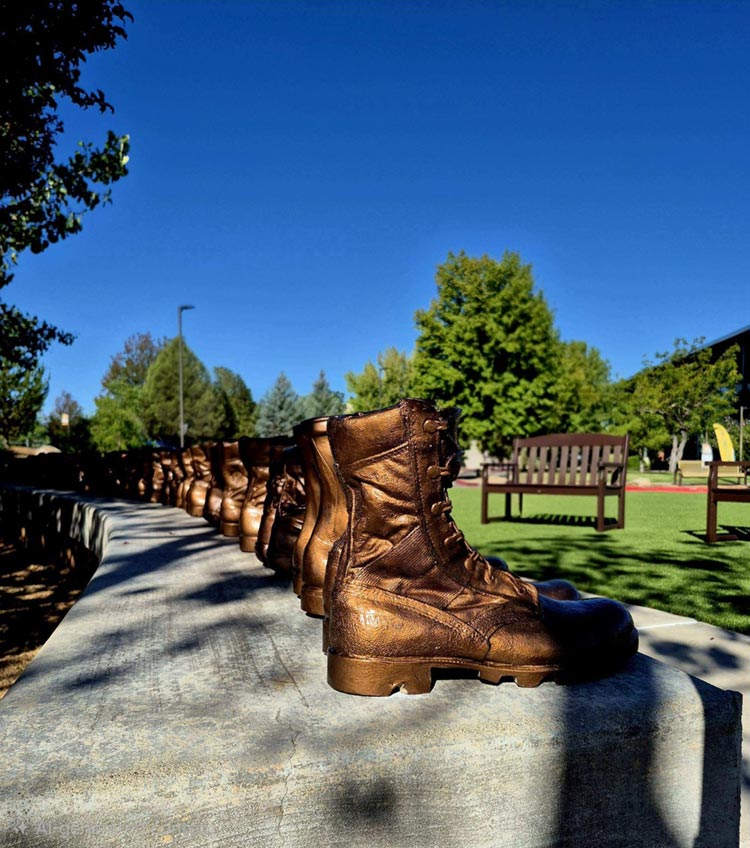 Memorial boots with the campus grounds in the background.